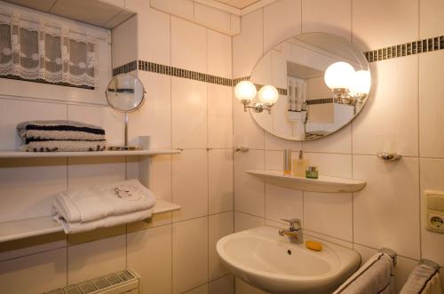 a white bathroom with a sink and a mirror at Ferienwohnungen Neuner in Plankenfels