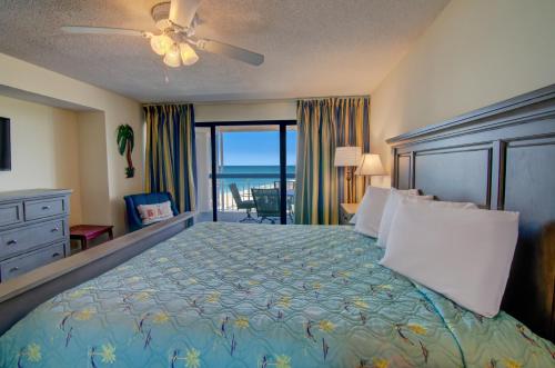 a bedroom with a bed with a view of the ocean at Forest Dunes Resort in Myrtle Beach