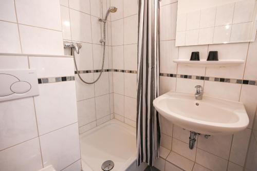 a white bathroom with a shower and a sink at Zur schönen Aussicht - FW 4 in Dahme