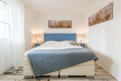 a bedroom with a bed with a blue headboard at Whg 10 - Laura in Zingst
