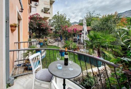 a table with a bottle of wine on a balcony at Villa Botticelli in Mostar