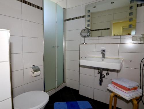 a bathroom with a toilet and a sink and a mirror at Fewo im Haus des Kurgastes in Heiligenhafen