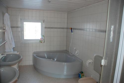 a bathroom with a large tub and a sink at Hof Reitmoor in Tackesdorf