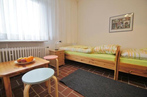 a bedroom with two beds and a table with a bowl of fruit at An der Allee 20 B in Dahme