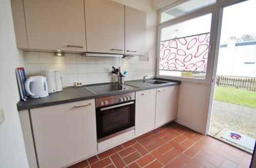 a kitchen with white cabinets and a sink and a window at An der Allee 20 B in Dahme