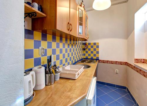 a kitchen with blue and yellow tiles on the wall at Villa Botticelli in Mostar