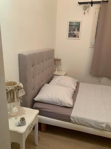 a small bedroom with a bed and a table at Apartment Limas in Avignon