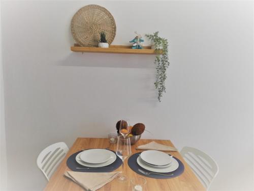 a dining room table with white plates and chairs at Casa Paixanita - jacuzzi & terrace downtown Olhao in Olhão