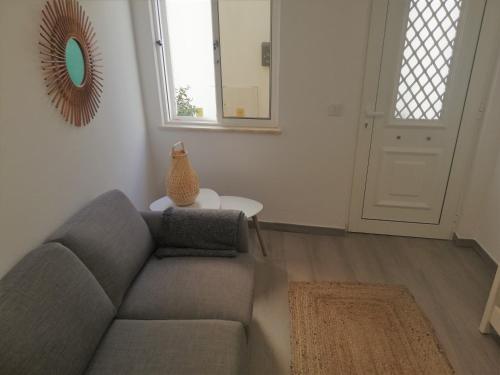 a living room with a couch and a vase on a table at Casa Paixanita - jacuzzi & terrace downtown Olhao in Olhão