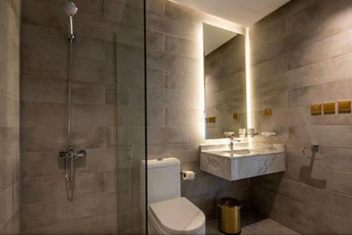 a bathroom with a shower and a toilet and a sink at Kyona Obhur - كيونا ابحر in Jeddah