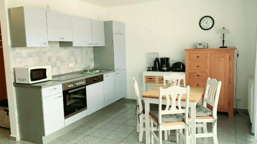 a kitchen with a table and chairs and a microwave at Ferienwohnungen Saida Wohnung 3 in Norden