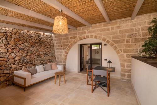 a living room with a couch and a stone wall at Masseria Corsano in Nardò