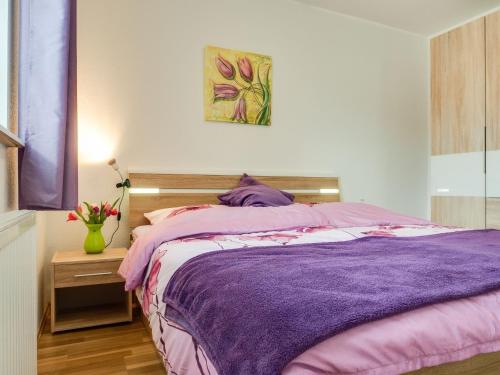 a bedroom with a bed with a purple blanket at Wiesenstraße 2 Whg 1 in Zingst