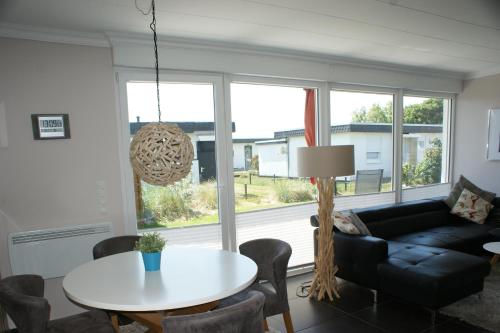 uma sala de estar com uma mesa e um sofá em Fehmarn-Ostseeferien FH3Traumbungalow Staberdorf 137 em Staberdorf