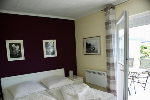 a bedroom with a white bed and a black wall at Fehmarn-Ostseeferien FH3Traumbungalow Staberdorf 137 in Staberdorf