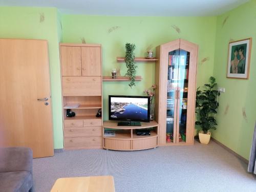 sala de estar con TV en un centro de entretenimiento de madera en Komfortferienwohnung "Morgenrot" en Schwaigs