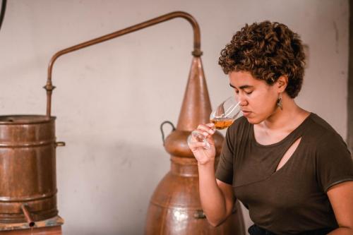 une femme boit un verre de vin dans l'établissement Hacienda Venecia Hostel, à Manizales