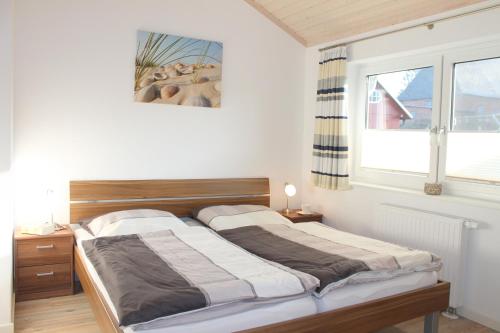 Schlafzimmer mit einem Bett und einem Fenster in der Unterkunft "Ferienhaus I - Hof Westensee" in Grömitz
