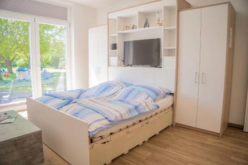 a bedroom with a bed with a tv on it at Scheune 8 in Gollendorf