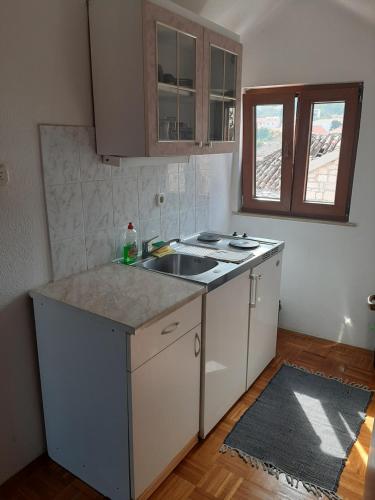 a kitchen with a sink and a counter top at Vila Dora Supetar in Supetar