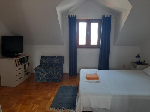 a bedroom with a bed and a window and a chair at Vila Dora Supetar in Supetar
