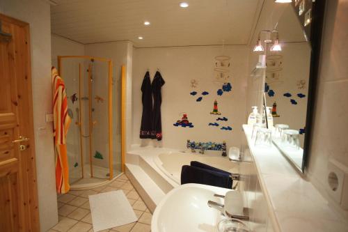 y baño con bañera, lavamanos y ducha. en Fehmarn-OstseeferienFewoAnders31593, en Neue Tiefe Fehmarn