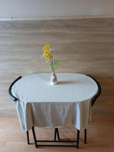 a table with a vase with flowers on it at Fancsika Vendégház in Debrecen