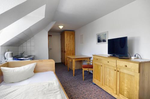 Kleines Zimmer mit einem Bett und einem TV in der Unterkunft Altes Wasserwerk, App 5 in Zingst