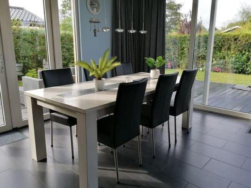 ノールトウェイクにあるBright Holiday Home in Noordwijk near Seaのダイニングルーム(テーブル、黒い椅子付)