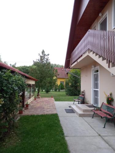 a yard with a bench and a house at Fancsika Vendégház in Debrecen