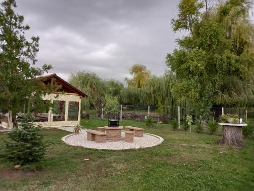 a park with benches and a grill in the grass at Fancsika Vendégház in Debrecen