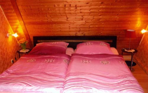 Bett in einem Zimmer mit rosa Bettwäsche und Kissen in der Unterkunft Mündlein in Eckernförde