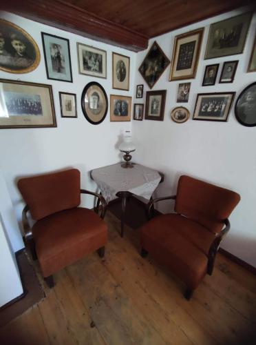 um quarto com uma mesa e duas cadeiras e fotografias na parede em Cafe Nostalgie čtyřlůžkový apartmán em Krásná Lípa