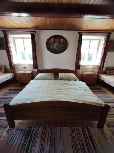 um quarto com uma cama grande e 2 janelas em Cafe Nostalgie čtyřlůžkový apartmán em Krásná Lípa