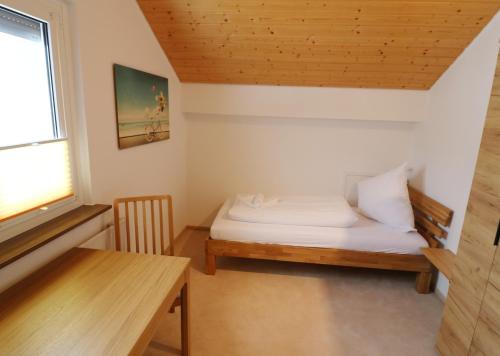Cette petite chambre comprend un lit et une table. dans l'établissement Haus Findling, 10 Personen, Schluchsee, Hochschwarzwaldkarte, à Schluchsee