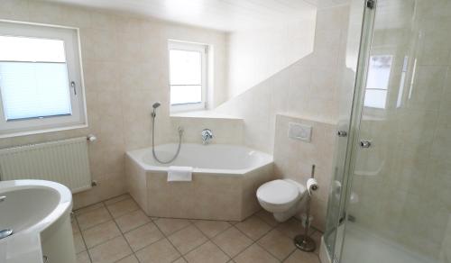 a bathroom with a tub and a toilet and a sink at Haus Findling, 10 Personen, Schluchsee, Hochschwarzwaldkarte in Schluchsee