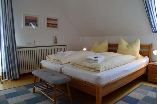 - une chambre avec un lit doté de draps blancs et d'une chaise dans l'établissement Flurstrasse - OG rechts, à Wyk auf Föhr