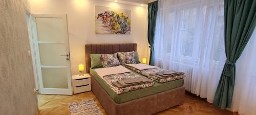 a small bedroom with a bed and a window at OLIVERA APARTMENT in Belgrade