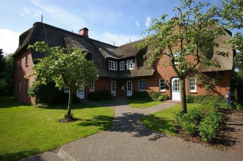 a large brick house with a tree in front of it at Haus Bornholm Whg 03 in Nieblum