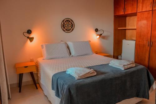 a bedroom with a bed with two towels on it at Pousada Quintal da Lua in Capitólio