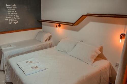a bedroom with a bed with two towels on it at Pousada Quintal da Lua in Capitólio