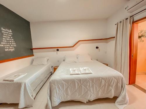 a bedroom with two beds and a chalkboard on the wall at Pousada Quintal da Lua in Capitólio