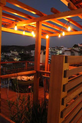 a deck with a pergola with lights on it at Pousada Quintal da Lua in Capitólio