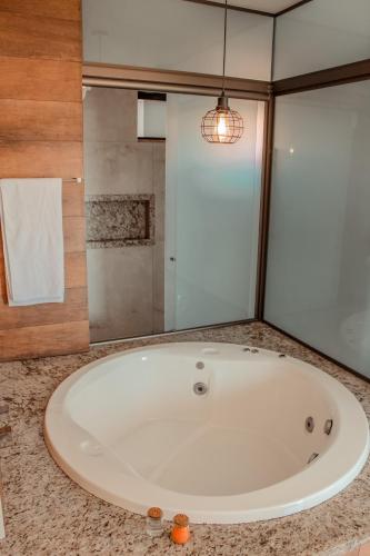 a large white bath tub in a bathroom at Pousada Quintal da Lua in Capitólio