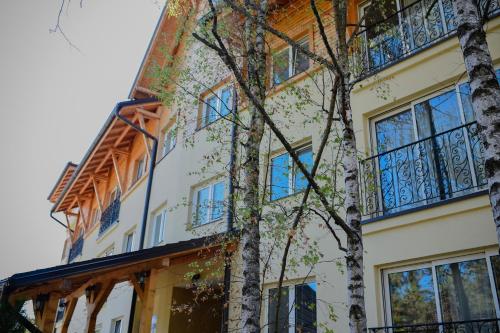 un edificio con un albero di fronte di Apartments Bramar a Zlatibor