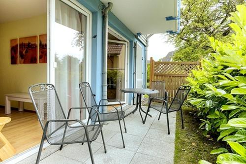 un patio con sillas y una mesa en un porche en Stollberg, FW4 en Zingst
