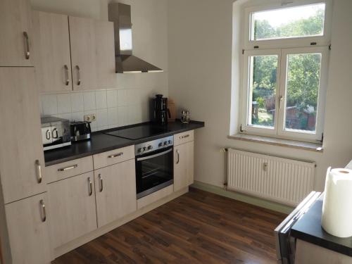 a kitchen with white cabinets and a window at Askanier in Ballenstedt