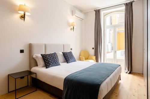 een slaapkamer met een groot bed en een raam bij BOUTIQUE Rentals-Art & Charm II Apt w/ Terrace in Porto