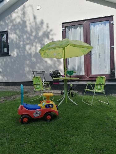 a toy car sitting in the grass under an umbrella at Chota Gher Apartment in Widnes