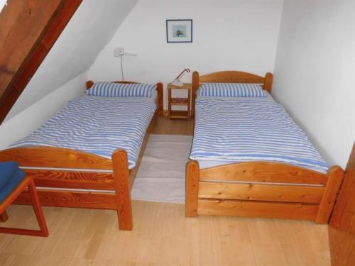 two twin beds in a room with a staircase at FeWo Vobbe in Dänischenhagen